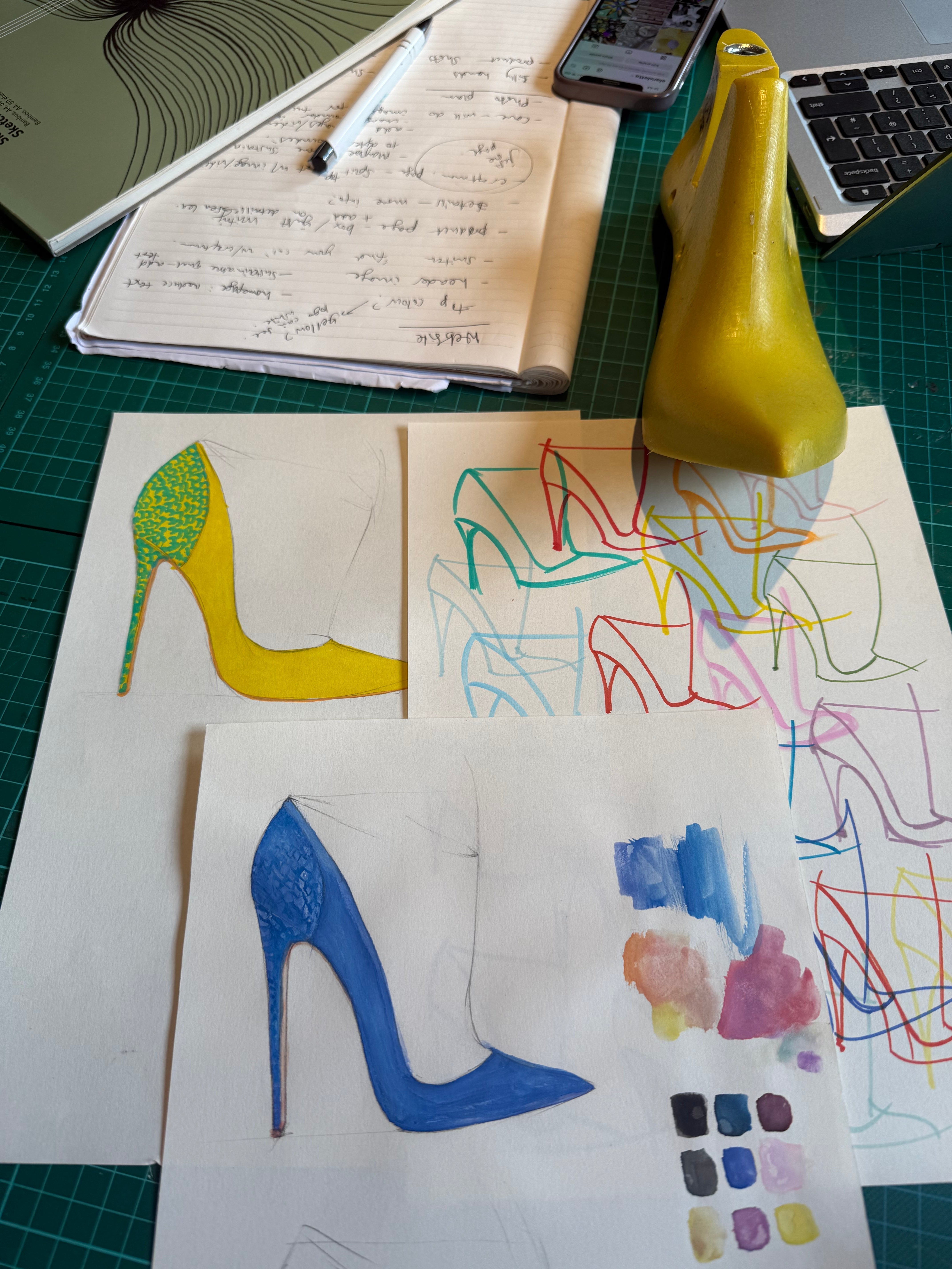 Elandetta shoe design sketches and colour studies featuring yellow and blue pointed heels, shown alongside hand-drawn concepts and materials during the creative development process behind the luxury collection.