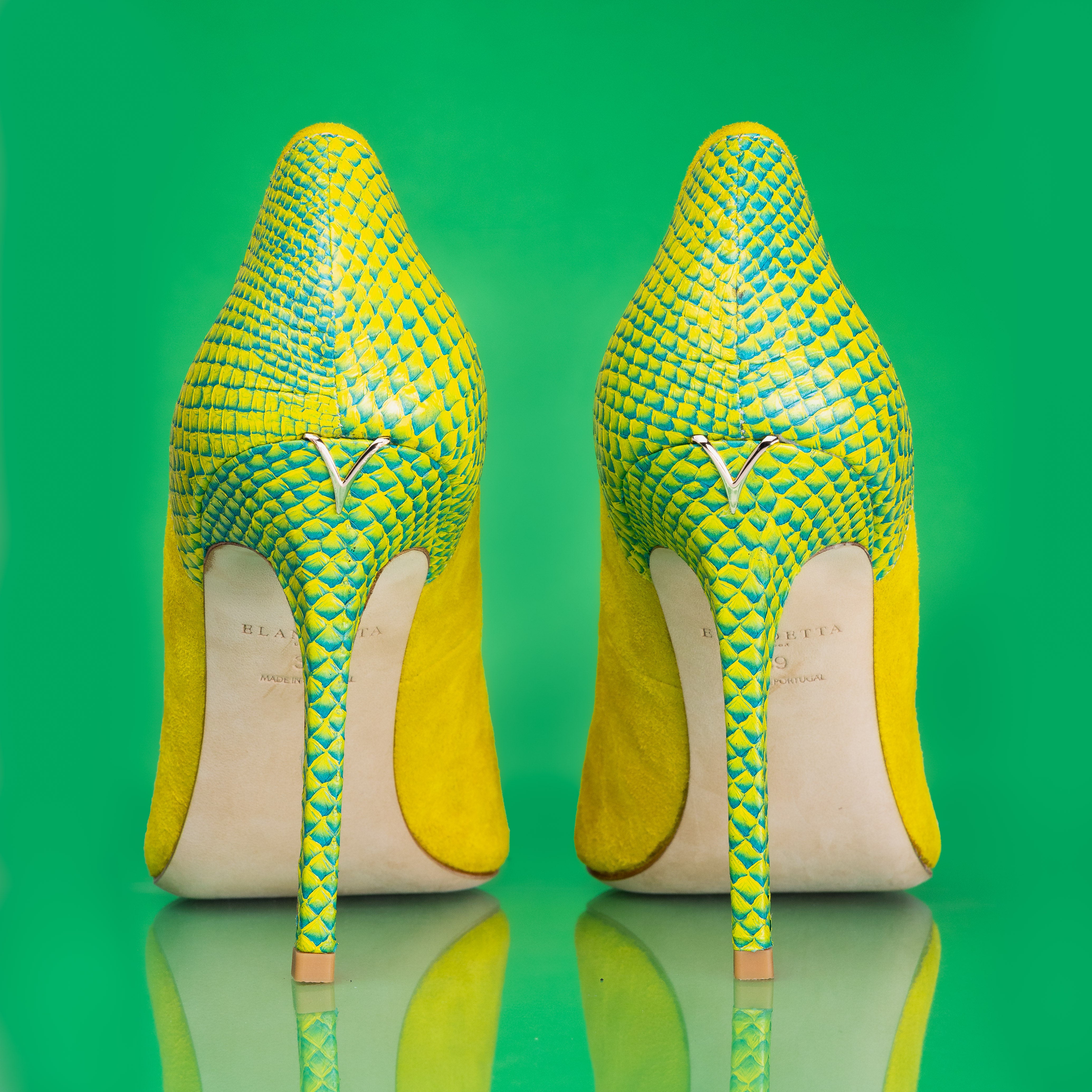 Rear angle of Elandetta Bouee heels highlighting green textured leather detailing and slim heel silhouette.