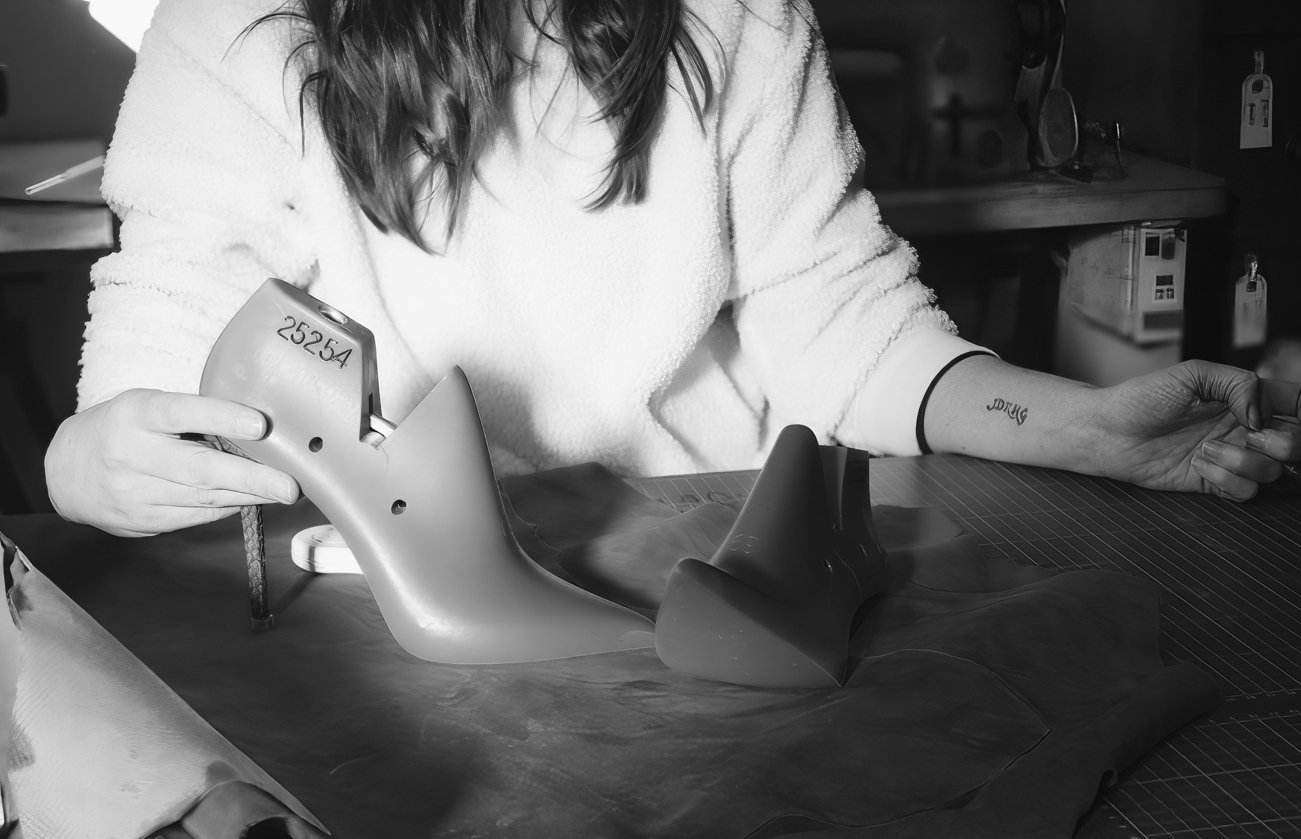 Close-up black and white image of shoemaking lasts beside British shoemaker Hetty Rose during the development of Elandetta luxury pointed heels. The sculpted forms highlight the craftsmanship, precision and technical artistry behind Elandetta’s colour-led footwear design process.