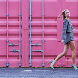 Model wearing Elandetta Sage Green suede heels with soft aqua blue undertones styled against a bold pink backdrop.