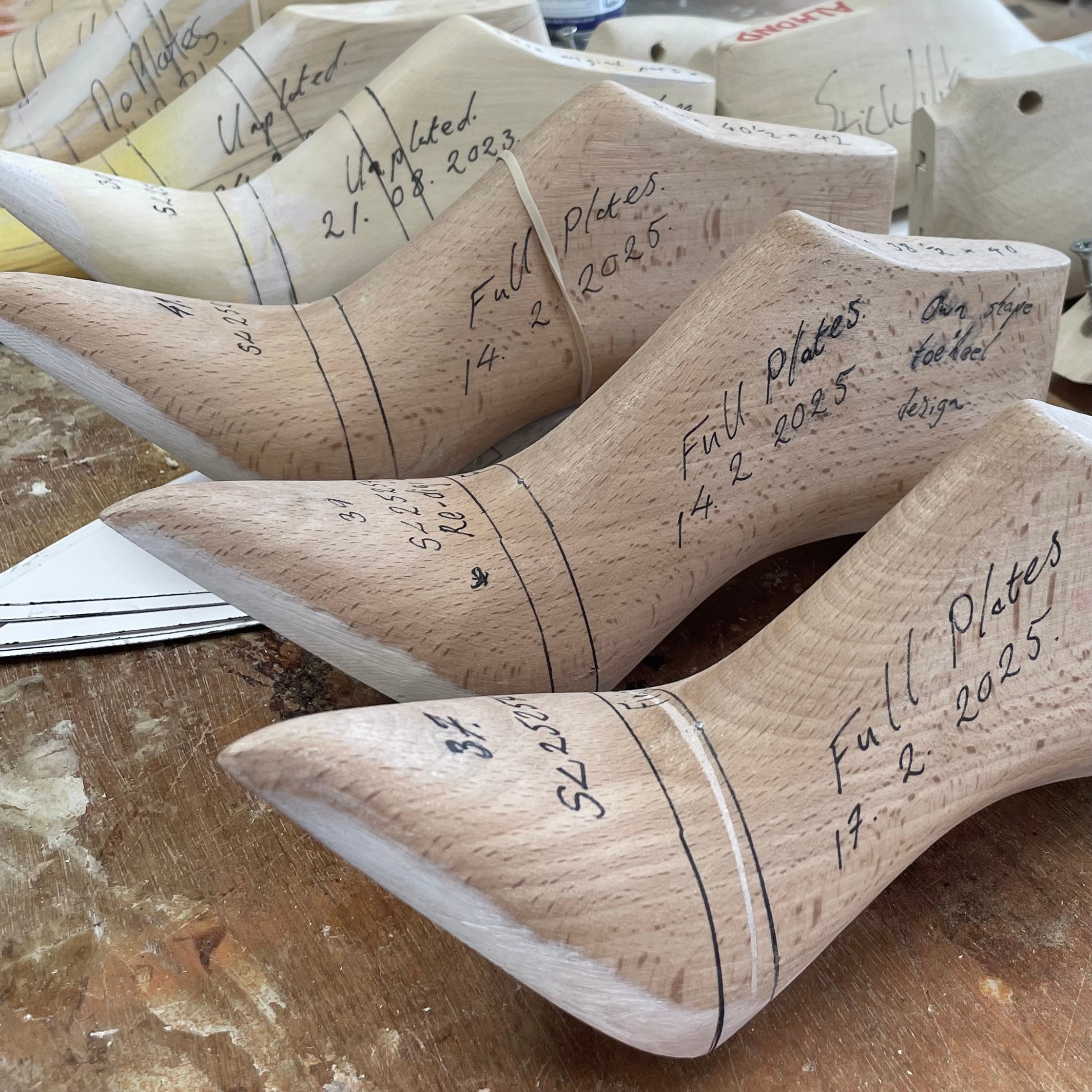Wooden shoe lasts made in Northampton at Springline lasts, with handwritten notes on a wooden surface