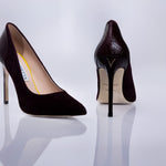 A pair of pointed-toe high heels by Elandetta, shown from the front and back on a reflective white surface. The shoes feature a dark burgundy suede upper with a textured black patent leather heel counter, a slim stiletto heel, and a beige insole.