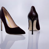 A pair of pointed-toe high heels by Elandetta, shown from the front and back on a reflective white surface. The shoes feature a dark burgundy suede upper with a textured black patent leather heel counter, a slim stiletto heel, and a beige insole.