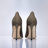 A pair of women's pointed-toe stiletto pumps shown from the back, featuring a taupe suede leather, with a light beige insole and black heels, set against a clean white background.